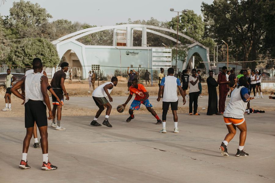 Des jeunes jouent au basket sur un terrain de quartier