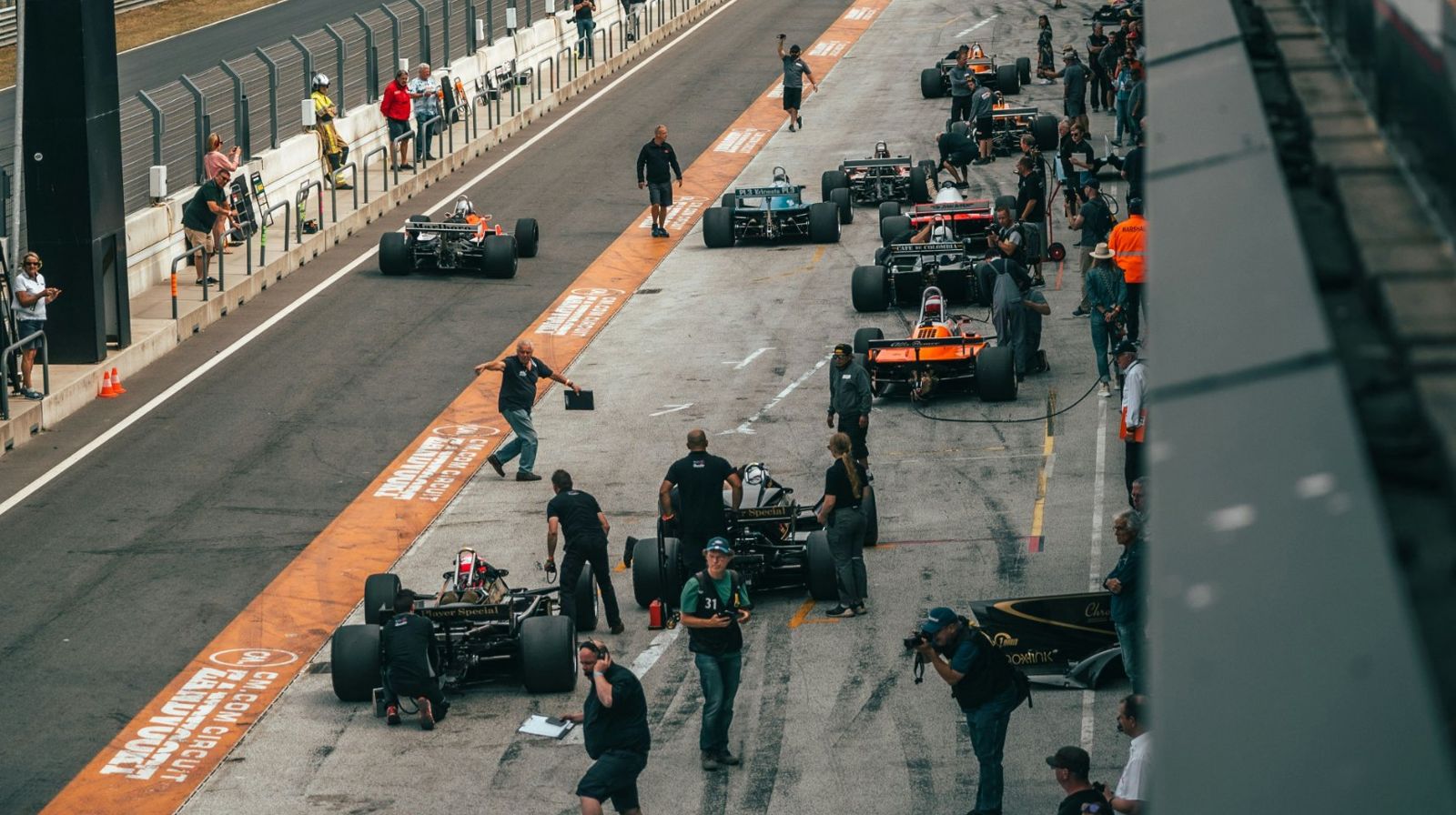 Voitures de course et mécaniciens dans la voie des stands d'un circuit